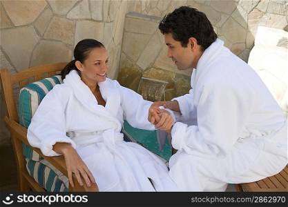 Couple in bathrobes relaxing outdoors