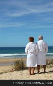 Couple in bathrobes watching the sea