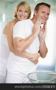 Couple in bathroom embracing and smiling