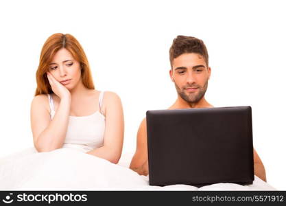 Couple in bed - man&rsquo;s watching something on his computer and woman doesn&rsquo;t like it