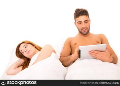 Couple in bed - man&rsquo;s watching something on his computer and woman doesn&rsquo;t like it