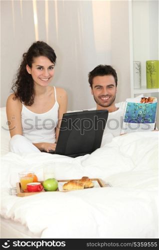 Couple in bed with a laptop
