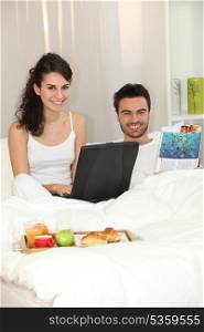 Couple in bed with a laptop