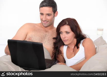 couple in bed with laptop