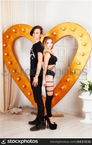 couple in black cloth near golden heart