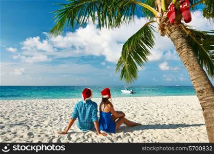 Couple in blue clothes on a tropical beach at christmas