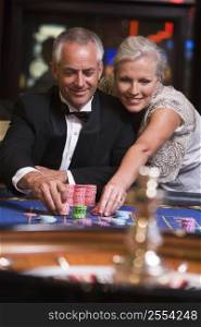 Couple in casino playing roulette and smiling (selective focus)