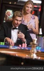 Couple in casino playing roulette and smiling (selective focus)
