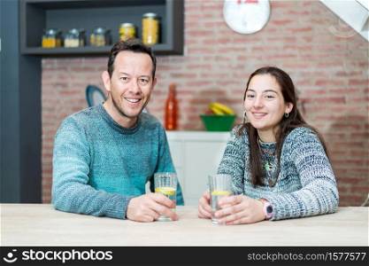 Couple in casual clothes dinner room with glass of water on table