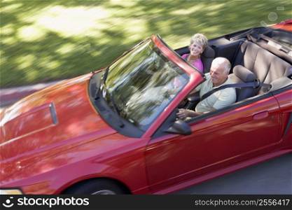 Couple in convertible car smiling