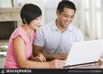 Couple in dining room with laptop smiling