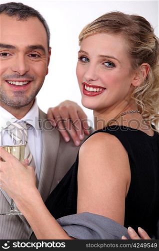 Couple in evening wear drinking champagne