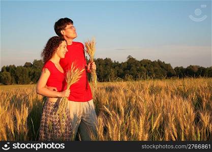 Couple in field with wheat in hands