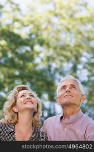 Couple in forest looking up