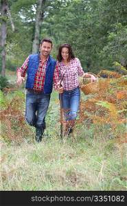 Couple in forest picking mushrooms in autumn