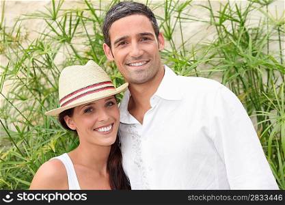 Couple in front of green branches