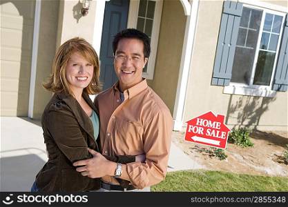 Couple in front of new house, portrait