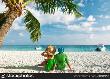 Couple in green clothes on a tropical beach at Maldives