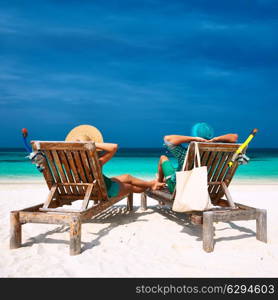 Couple in green relax on a tropical beach at Maldives