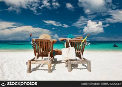 Couple in green relax on a tropical beach at Maldives