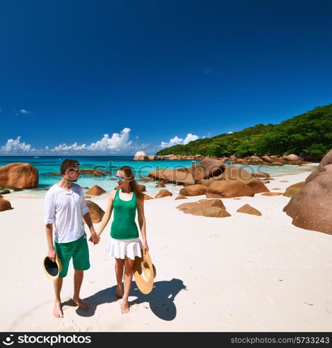 Couple in green walking on a tropical beach at Seychelles