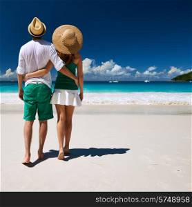 Couple in green walking on a tropical beach at Seychelles