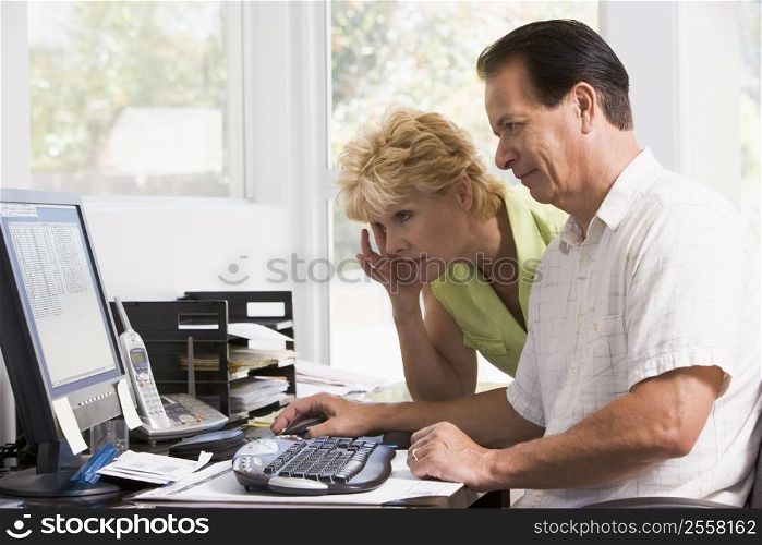Couple in home office at computer frowning