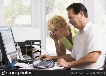 Couple in home office at computer frowning