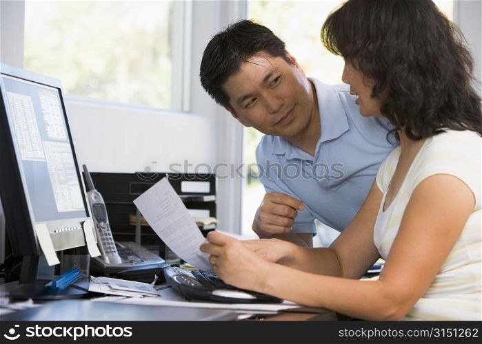 Couple in home office with computer and paperwork