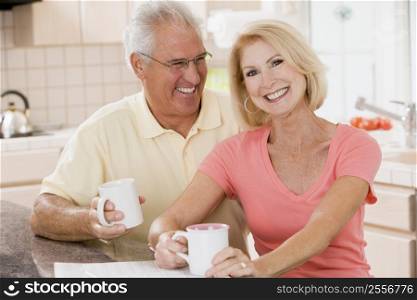 Couple in kitchen with coffee smiling