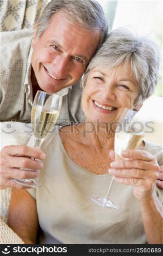 Couple in living room drinking champagne and smiling