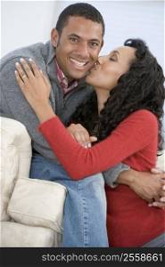Couple in living room kissing and smiling