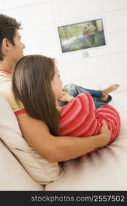 Couple in living room watching television