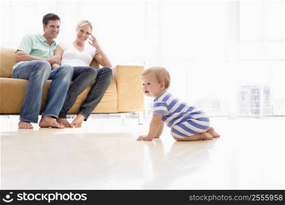 Couple in living room with baby smiling