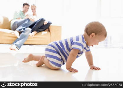 Couple in living room with baby smiling