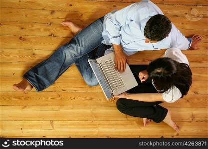 Couple in living-room with laptop computer, top-view
