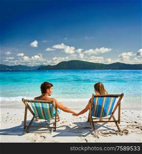 Couple in loungers on a tropical beach at Thailand
