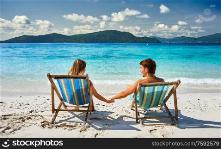 Couple in loungers on a tropical beach at Thailand