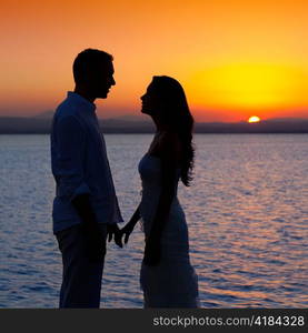 couple in love back light silhouette at lake orange sunset