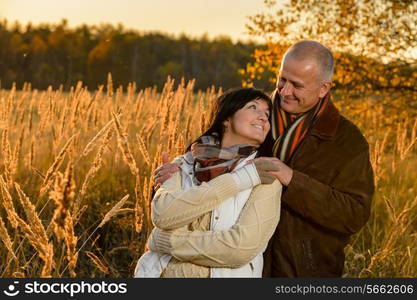 Couple in love embracing autumn sunset countryside looking each other