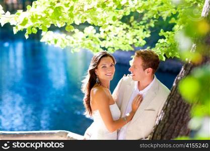 couple in love hug in forest tree blue lake outdoors