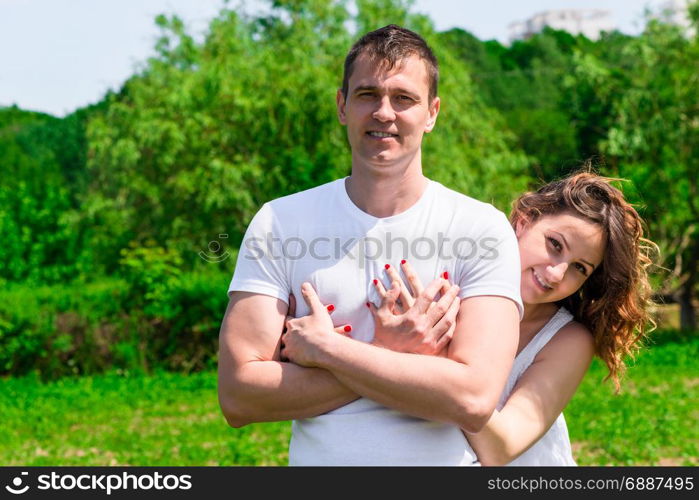 Couple in love hugging on lawn in park, woman waiting for baby