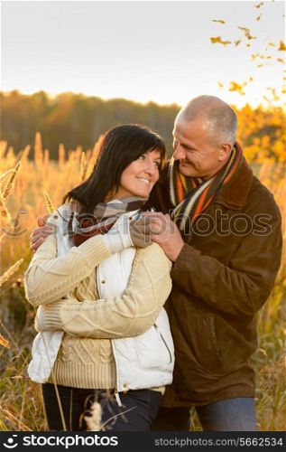 Couple in love hugging sunset autumn countryside looking each other