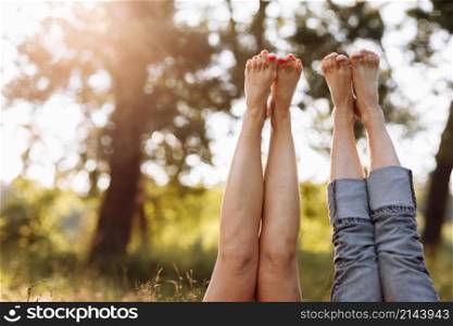 couple in love lying in the grass and lifting their legs up. summer sunny day.. couple in love lying in the grass and lifting their legs up. summer sunny day