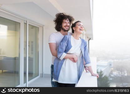 Couple in love sharing emotions and happiness while hugging on the balcony at home