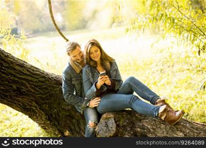 Couple in love sitting on a tree in autumn park