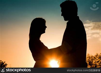 Couple in love touching each other backlit in a sunset in summer