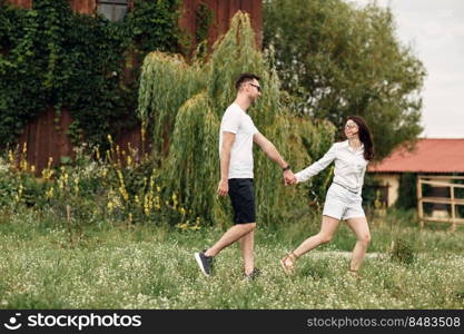 Couple in love walks near a large wooden mill on summer day. man and woman are having fun outdoors. Couple in love walks near a large wooden mill on summer day. man and woman are having fun outdoors.