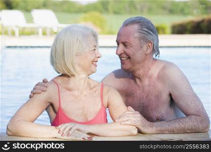 Couple in outdoor pool smiling