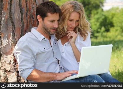 Couple in park on laptop